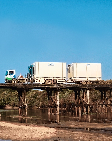 Caminhão transporta containers sobre uma ponte